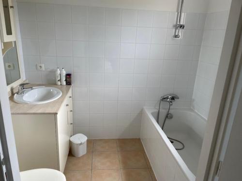 La salle de bains est pourvue d'un lavabo, d'une baignoire et de toilettes. dans l'établissement maison COSY LES FORGES, à Les Forges