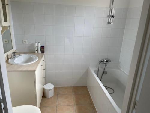 a bathroom with a sink and a tub and a toilet at maison COSY LES FORGES in Les Forges