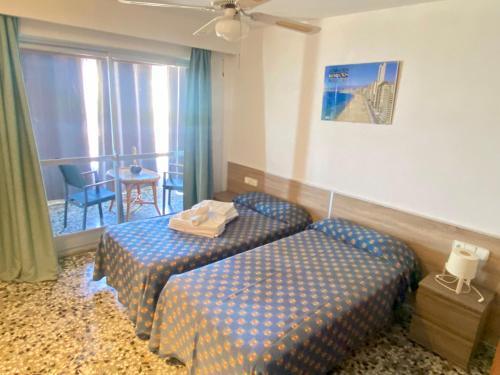 um quarto de hotel com duas camas e uma janela em Tor Serena-Fincas Benidorm em Benidorm