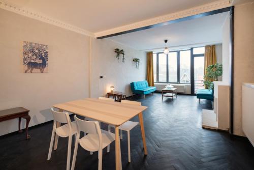 a living room with a wooden table and chairs at Charming and Spacious Apartments in the Heart of Antwerp in Antwerp