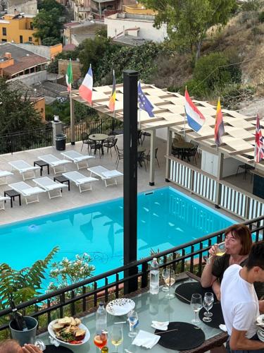 un grupo de personas sentadas en una mesa junto a una piscina en B&B Montemare, en Agrigento