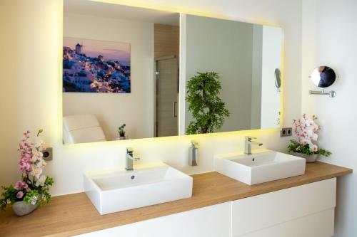 a bathroom with two sinks and a large mirror at Apartment Skyline Graz Villa Stattegg in Stattegg