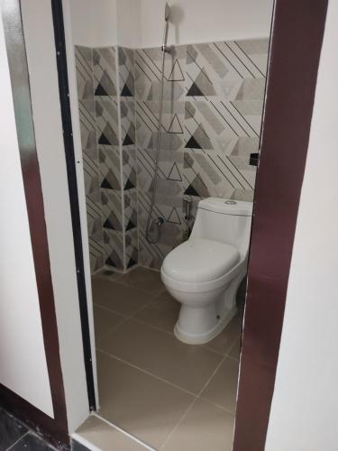 bagno con servizi igienici bianchi in camera di D & G Transient House a Pintuyan