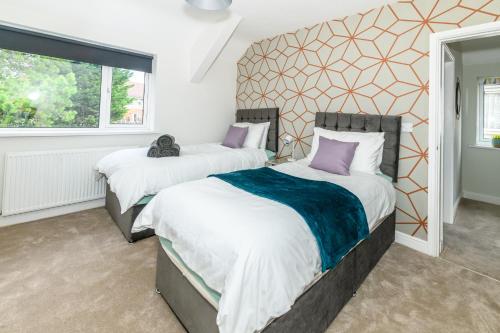 a bedroom with two beds and a window at Stylish 3 Bed House Near Hospital, Racecourse, Free Parking 