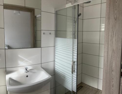 a bathroom with a sink and a glass shower at Wynajem pokoi in Władysławowo