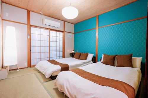 Postel nebo postele na pokoji v ubytování USJまで電車で5分 Meeno Home西九条美の宿親子向け民泊 マリオパワーアップバンド ReFa美顔シャワー付き 広々空間 好アクセス