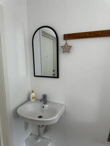 a bathroom with a sink and a mirror on the wall at Storfossen Hostel in Gratangen