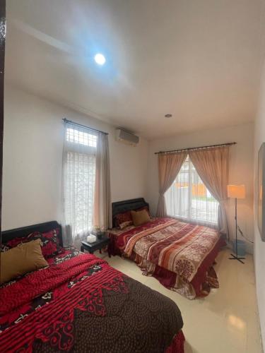 - une chambre avec 2 lits et 2 fenêtres dans l'établissement Shaka House at alun alun kidul, à Timuran