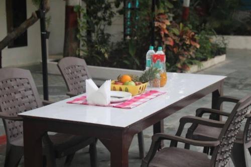 a table with a bowl of fruit and drinks on it at Classic Villa 3 BHK Villa with pool in chondhi, Kihim, Alibag in Alibag