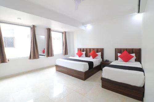 a bedroom with two beds with red pillows at The marine Aero Near IGI T3 Airport in New Delhi