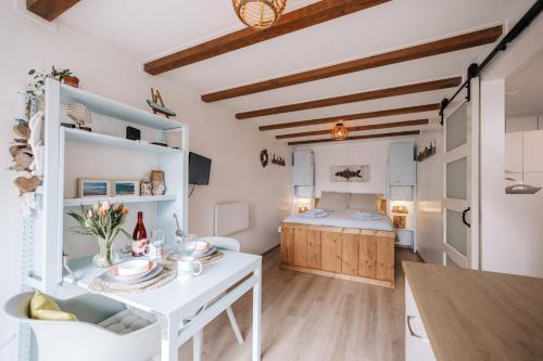 a kitchen and living room with a table and a bed at De Jutter - Zandvoort in Zandvoort