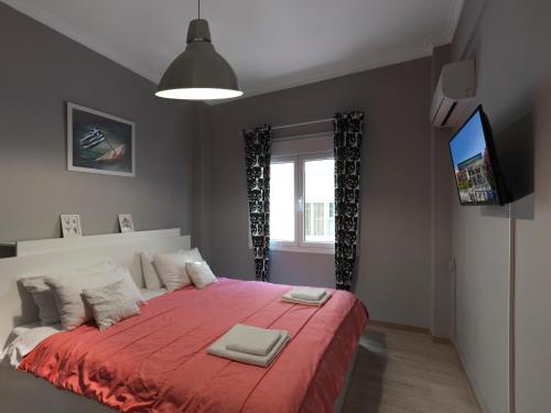um quarto com uma cama grande e um cobertor vermelho em The Acropolis Apartment em Atenas
