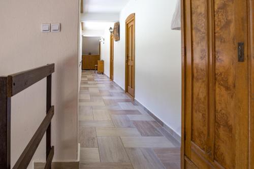 a hallway with wooden floors in a building at Napkelte Vendégház in Orfű