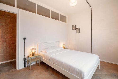 a white bedroom with a large bed and two lamps at Charming and Spacious Apartments in the Heart of Antwerp in Antwerp