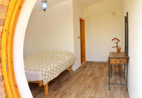 Schlafzimmer mit einem Bett, einem Tisch und einem Spiegel in der Unterkunft Heredot's house in Finike