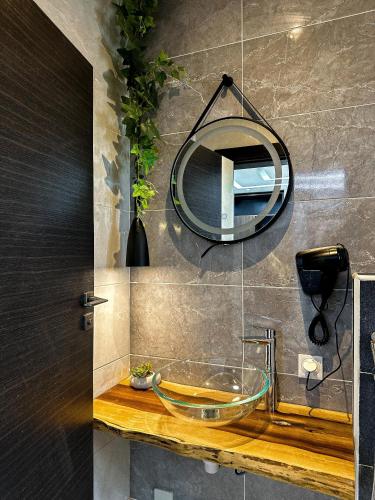 a bathroom with a glass sink and a mirror at Klik Klak Appart Hotel in Cotonou