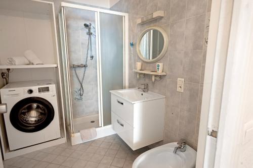 une salle de bain avec une machine à laver et un lavabo dans l'établissement Mar-y-Nan Family Apartment - Happy Rentals, à Menton