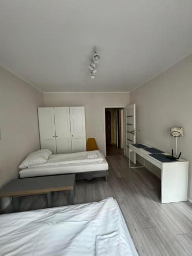 a room with two beds and a desk in it at Abra V Apartament in Poznań