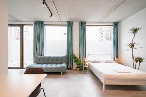 un dormitorio con una cama y un sofá en Opera Square Apartments in Antwerp Centre, en Amberes