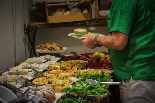 a man holding a plate of food at a buffet at Linda Port Hotel in Istanbul