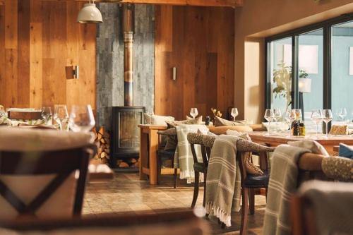 a dining room with a fireplace and tables and chairs at Port William Inn in Tintagel