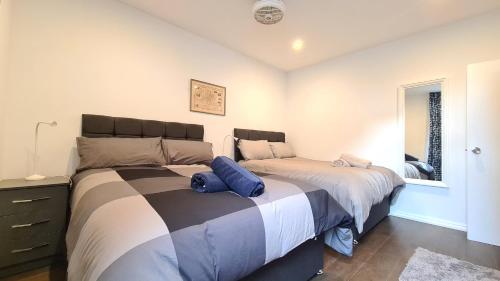two beds sitting next to each other in a bedroom at Delightful 2 Bedroom Apartment! in London