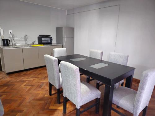 een eettafel met stoelen en een keuken bij Punta Blanca in Salta