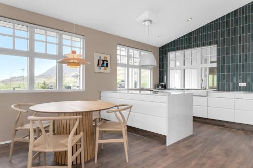 a kitchen with a table and a table and chairs at Himri the mountain villa in Mosfellsbær