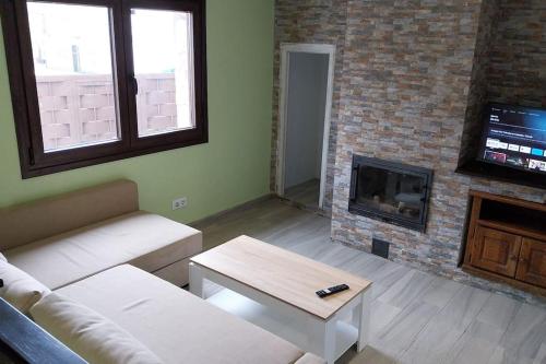 a living room with a couch and a fireplace at Casa Gabritana in Sotillo de las Palomas