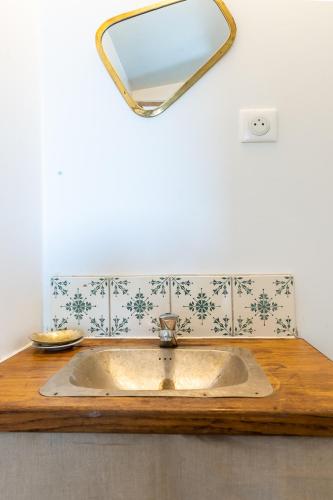 La salle de bains est pourvue d'un lavabo et d'un miroir. dans l'établissement La maison de Frida, à Forcalquier