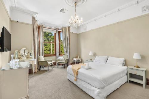 een slaapkamer met een wit bed en een groot raam bij The Mansion in Hamilton