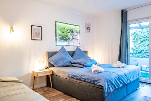 um quarto com uma cama com almofadas azuis e uma janela em #621 Geräumig & Komfortabel / Netflix & Prime em Essen