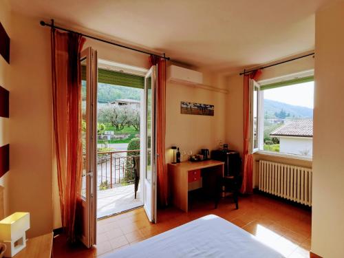 a bedroom with a bed and a desk and a window at Ristorante Le Rasole in Garda