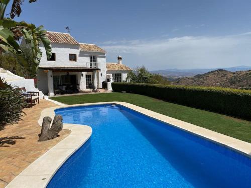 ein blauer Pool vor einem Haus in der Unterkunft Charming Spanish Finca in beautiful nature in Málaga
