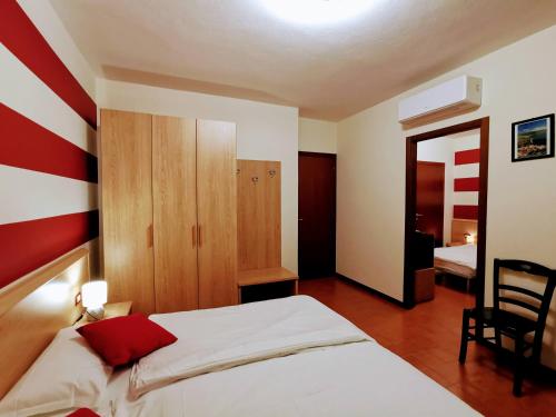 a bedroom with a bed with a red and white striped wall at Ristorante Le Rasole in Garda