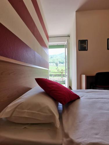 a bedroom with a bed with a red pillow on it at Ristorante Le Rasole in Garda