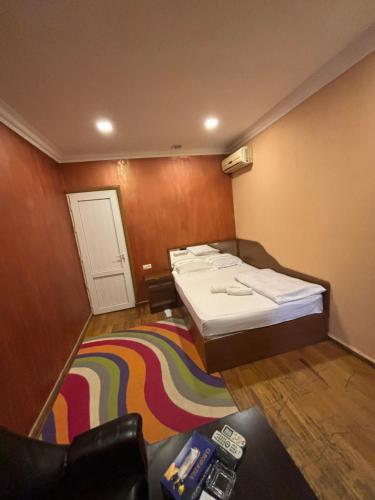 Pokój z 4 łóżkami i tęczowym dywanem w obiekcie Achajur w Erywaniu
