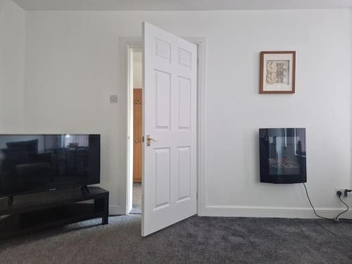an open door to a living room with a tv at M Rooms - entire 1 bedroom, furnished pub flat in Kirk of Shotts