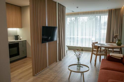 sala de estar con mesa y TV en una habitación en Charming Apartment In Zeimena's Street en Kaunas
