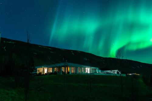 a house under the northern lights at night at Himri the mountain villa in Mosfellsbær