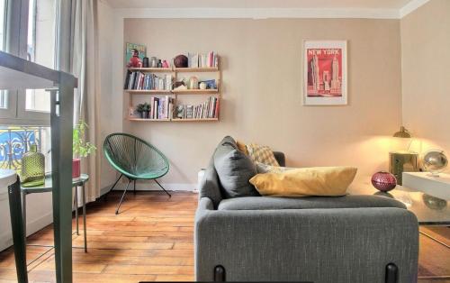 a living room with a couch and a table at Appartement cosy Clichy in Clichy