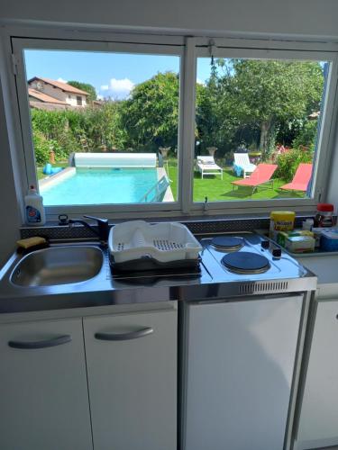 une cuisine avec un évier, une cuisinière et une fenêtre dans l'établissement Pause nature au Teich avec piscine, au Teich