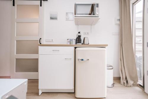 a kitchen with two white refrigerators in a room at De Jutter - Zandvoort in Zandvoort
