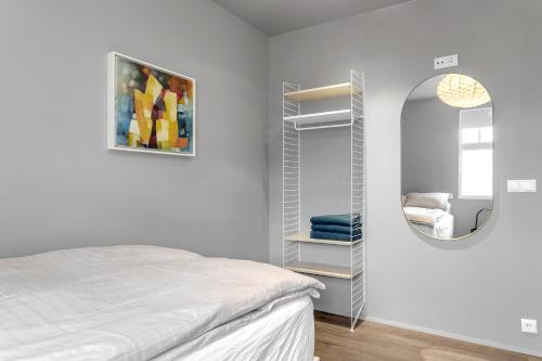 a bedroom with a bed and a mirror at Himri the mountain villa in Mosfellsbær