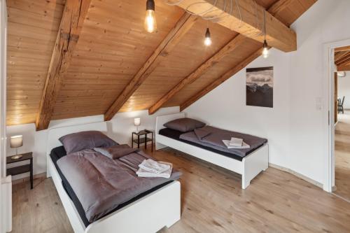 a bedroom with two beds and a wooden ceiling at FENUS Grabs Gemütliche Ferienwohnung SGT06 in Grabs