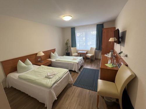 a hotel room with two beds and a chair at Reitanlage Plath in Timmendorf