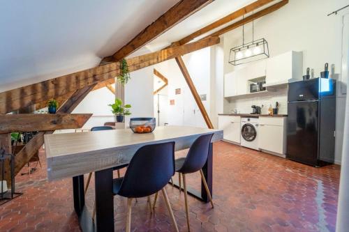 uma cozinha e sala de jantar com mesa e cadeiras em Authentique studio hypercentre - clim - wifi em Nîmes