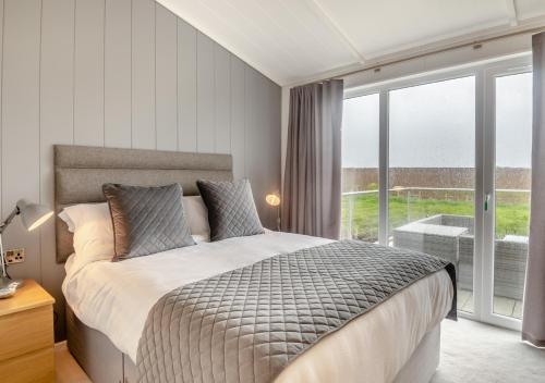 a bedroom with a bed and a large window at Crome in Blakeney
