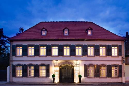 um grande edifício branco com as suas luzes acesas em Villa Diana em Molsheim