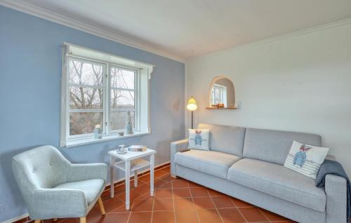 a living room with a couch and a chair at 2 Bedroom Lovely Home In Galmsbüll in Galmsbüll